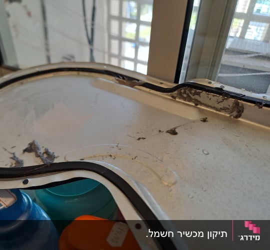 תעלת אוויר מפורקת של מייבש כביסה עם הצטברות מוך במהלך תיקון